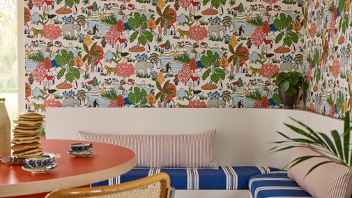 Colourful wallpaper with animals on situated behind a dinner table